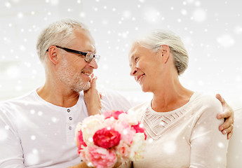 Image showing happy senior couple with bunch of flowers at home
