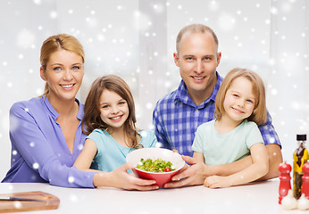 Image showing happy family with two kids showing salad in bowl