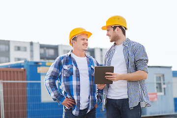 Image showing smiling builders in hardhats with tablet pc