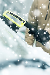 Image showing closeup of man cleaning snow from car