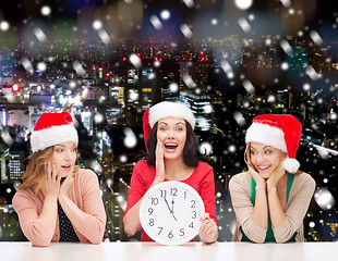 Image showing smiling women in santa helper hat with clock