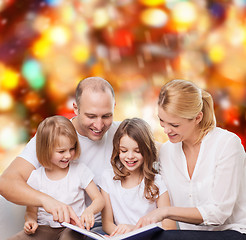 Image showing happy family with book at home