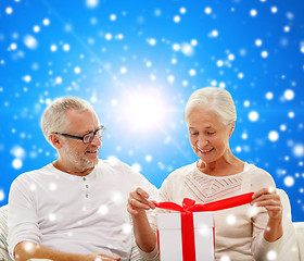 Image showing happy senior couple with gift box at home