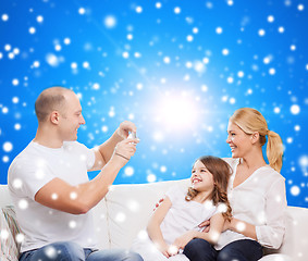 Image showing happy family with camera at home