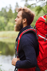 Image showing smiling man with beard and backpack hiking