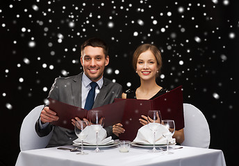 Image showing smiling couple with menus at restaurant