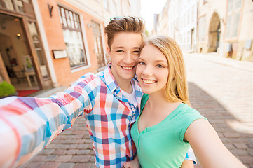 Image showing smiling couple with smartphone in city