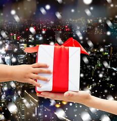 Image showing close up of child and mother hands with gift box