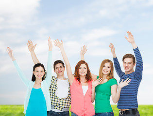 Image showing group of smiling students waving hands