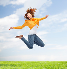 Image showing smiling young woman jumping high in air