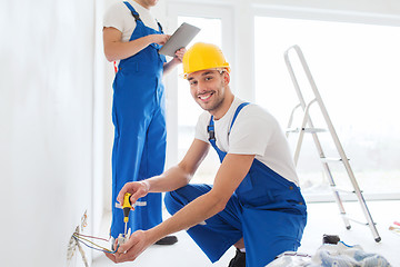 Image showing builders with tablet pc and equipment indoors