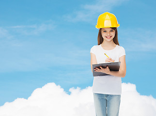 Image showing smiling little girl in hardhat with clipboard