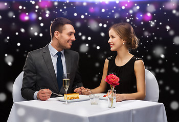 Image showing smiling couple eating dessert at restaurant