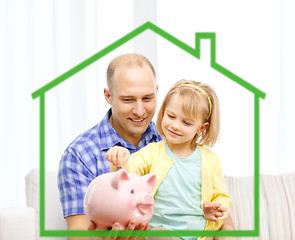 Image showing happy father and daughter with big piggy bank