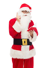 Image showing man in costume of santa claus with notepad