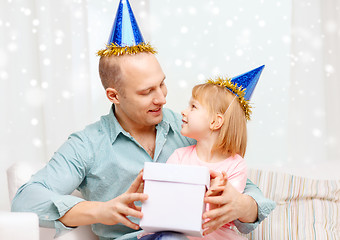 Image showing father and daughter in party caps with gift box