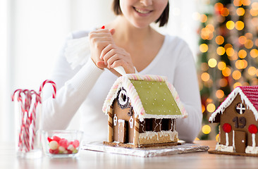 Image showing close up of woman making gingerbread houses