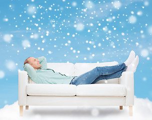 Image showing smiling man lying on sofa