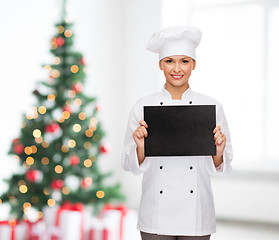 Image showing smiling female chef with black blank paper