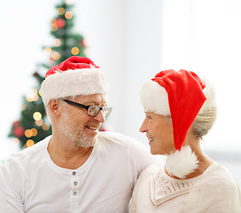 Image showing happy senior couple in santa helper hats