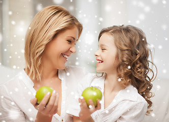 Image showing happy mother and daughter holding green apples