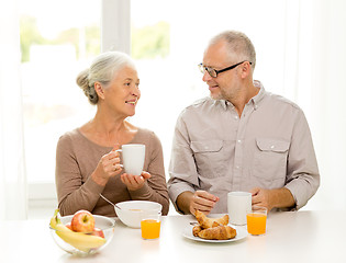 Image showing happy senior couple having breakfast at home