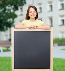 Image showing happy little girl with blank blackboard