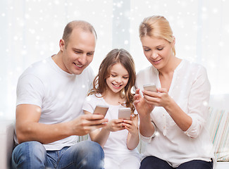 Image showing happy family with smartphones at home