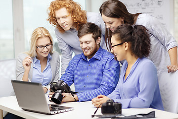 Image showing smiling team with laptop and photocamera in office