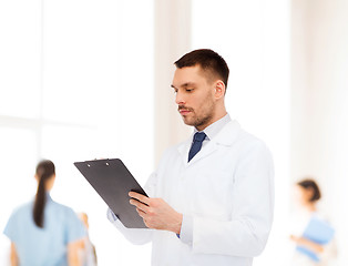 Image showing serious male doctor with clipboard