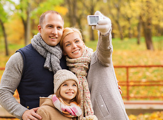 Image showing happy family with camera in autumn park