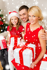 Image showing smiling family holding many gift boxes