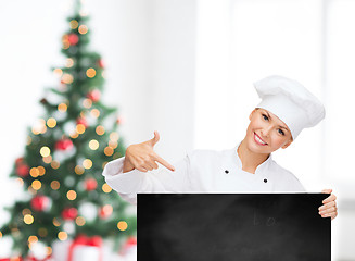 Image showing smiling female chef with white blank board