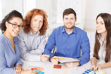 Image showing team with color samples and blueprint at office