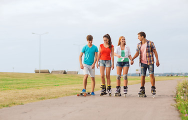 Image showing group of smiling teenagers with roller-skates