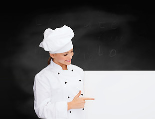 Image showing smiling female chef with white blank board