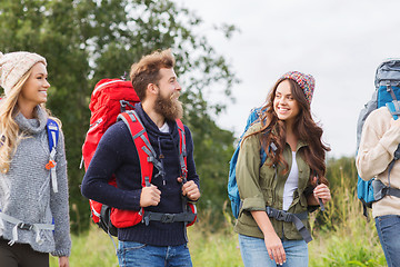 Image showing group of smiling friends with backpacks hiking