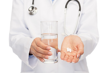 Image showing close up of doctor offering pills and water