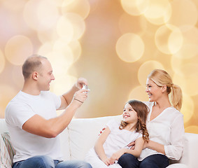 Image showing happy family with camera at home