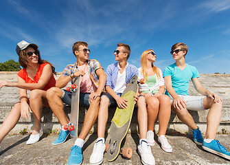 Image showing group of smiling friends sitting on city street