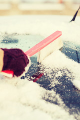 Image showing woman cleaning snow from car back window