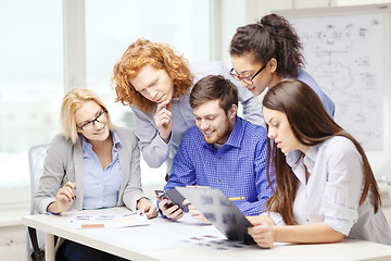 Image showing creative team with papers and clipboard at office