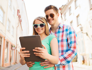 Image showing smiling couple with tablet pc in city