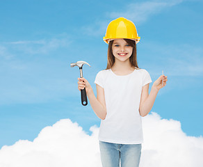 Image showing smiling little girl in hardhat with hammer