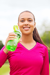 Image showing smiling woman drinking from bottle