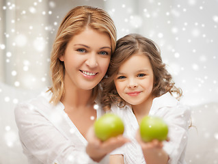 Image showing happy mother and daughter holding green apples