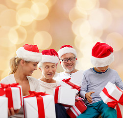 Image showing happy family in santa helper hats with gift boxes