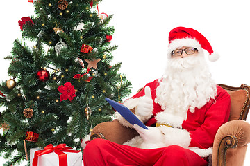 Image showing man in costume of santa claus with tablet pc