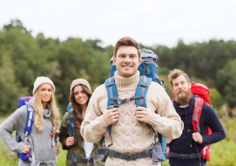 Image showing group of smiling friends with backpacks hiking