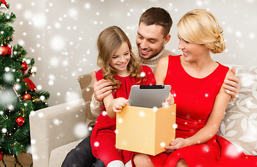 Image showing smiling family taking tablet pc out from gift box